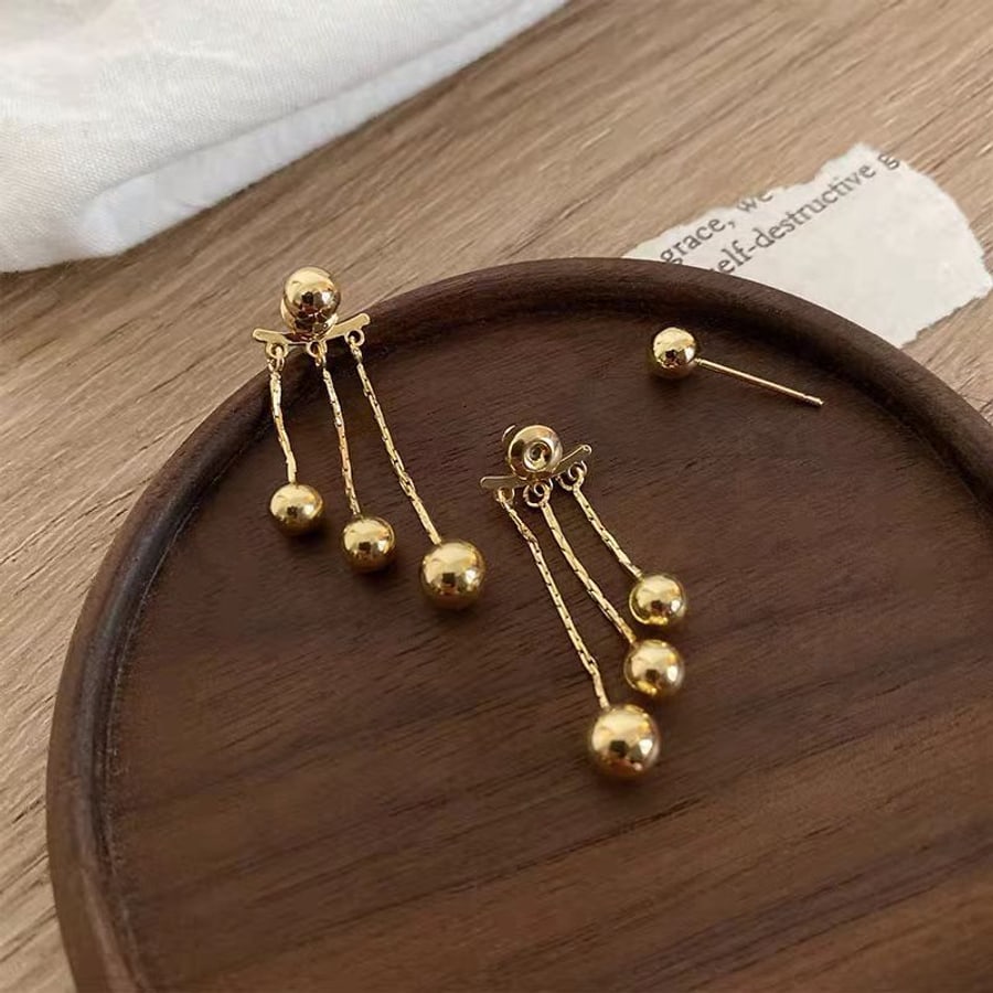 Aretes largos dorados con bolitas