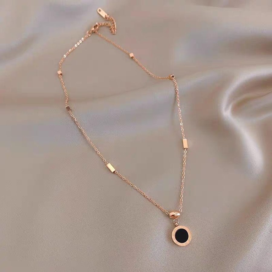 Cadena tono oro rosa con dije circular negro